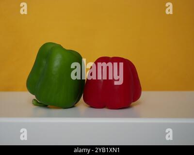 Peperoni verdi e rossi paprika dolce su sfondo giallo. Foto Stock