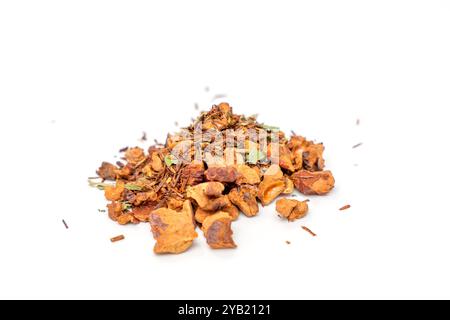 Una pila di tè natalizio con cannella e mela su sfondo bianco. Il tè è sparso e mescolato insieme, creando un quadro colorato e aromatico Foto Stock