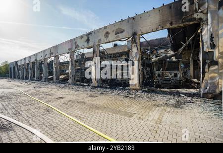 Stadtallendorf, Germania. 16 ottobre 2024. Veicoli di emergenza bruciati nella sala veicoli. Il nuovo deposito di attrezzature del dipartimento dei vigili del fuoco volontario di Stadtallendorf è bruciato, completo di veicoli e attrezzature, causando milioni di danni. Crediti: Andreas Arnold/dpa/Alamy Live News Foto Stock