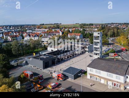 Stadtallendorf, Germania. 16 ottobre 2024. Immagine del drone i vigili del fuoco sono occupati con lavori post-estinguenti. Il nuovo deposito di attrezzature del dipartimento dei vigili del fuoco volontario di Stadtallendorf è completamente bruciato con veicoli e attrezzature, causando milioni di danni. Crediti: Andreas Arnold/dpa/Alamy Live News Foto Stock