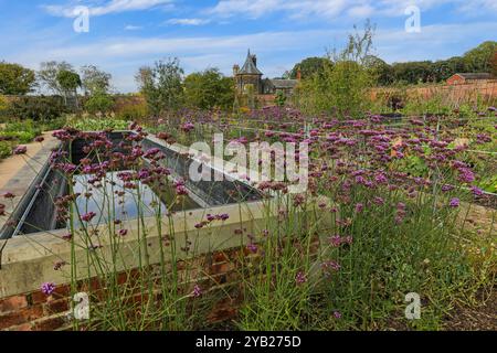 Parco acquatico con il Garden Cottage sullo sfondo in autunno presso RHS Garden Bridgewater Gardens, Worsley, Greater Manchester, Inghilterra, Regno Unito Foto Stock