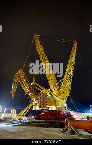 enorme gru in acciaio ad alte prestazioni in un sito di limitazione di notte Foto Stock