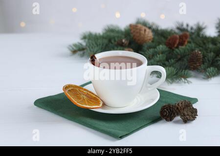 Ottimo cacao in tazza e rami di abete su un tavolo di legno bianco Foto Stock