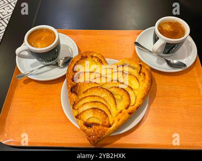 Torta di mele a forma di cuore e due tazze di caffè. Foto Stock