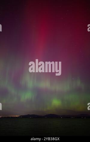 Aurora Boreale aurora boreale con colonna rossa e onde verdi sull'acqua Foto Stock