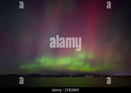 Aurora Boreale aurora boreale in rosa e verde sulla baia di Padilla Foto Stock