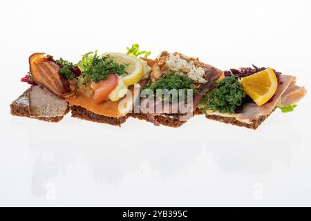 Salato smørrebrød danese con insalata di carne, pâté e bacon su rugbrød. Un classico sandwich a vista, perfetto per un pasto abbondante. Foto Stock