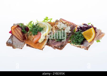 Salato smørrebrød danese con insalata di carne, pâté e bacon su rugbrød. Un classico sandwich a vista, perfetto per un pasto abbondante. Foto Stock