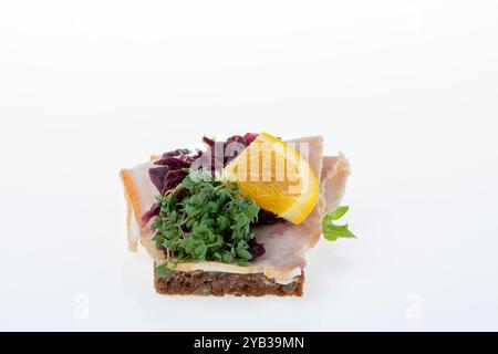 Salato smørrebrød danese con insalata di carne, pâté e bacon su rugbrød. Un classico sandwich a vista, perfetto per un pasto abbondante. Foto Stock