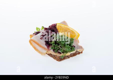 Salato smørrebrød danese con insalata di carne, pâté e bacon su rugbrød. Un classico sandwich a vista, perfetto per un pasto abbondante. Foto Stock