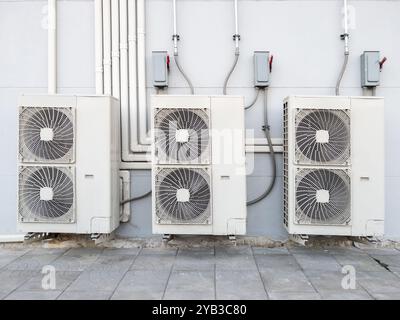 L'unità compressore dell'impianto di climatizzazione è appesa alla parete bianca dietro la stazione della monorotaia urbana, vista frontale con lo spazio di copia. Foto Stock