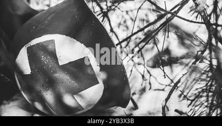 Il corpsman Helmet si trova vicino a Fallen Soldier. Elmetto metallico del soldato medico di fanteria dell'esercito degli Stati Uniti durante la seconda guerra mondiale. Reenactor vestito come soldato USA Foto Stock