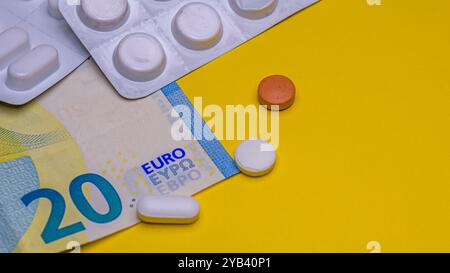 Medicinali e banconota in euro isolati su sfondo giallo Foto Stock