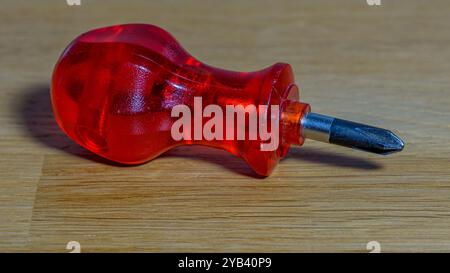 piccolo cacciavite rosso su fondo di legno Foto Stock