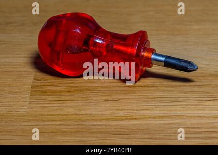 piccolo cacciavite rosso su fondo di legno Foto Stock