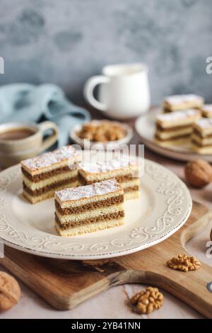 Torta tradizionale di noci su un piatto. Tazza di caffè e tovagliolo blu sullo sfondo. Foto Stock