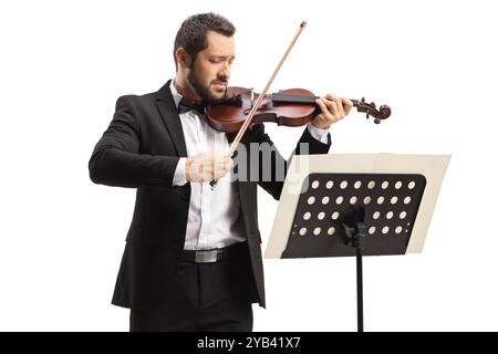 Violinista che suona un violino davanti a uno spartito isolato su sfondo bianco Foto Stock