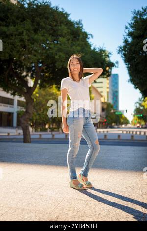 Bella giovane donna asiatica Jeans T-shirt in piedi Downtown Plaza San Jose pomeriggio Sunny Happy Foto Stock