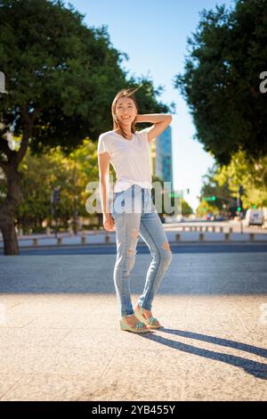 Bella giovane donna asiatica Jeans T-shirt in piedi Downtown Plaza San Jose pomeriggio Sunny Happy Foto Stock