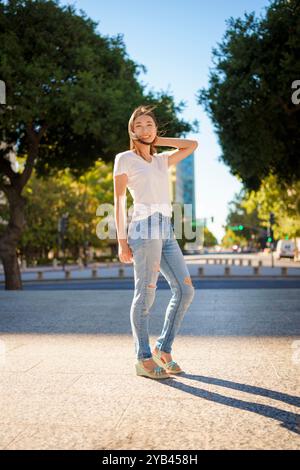 Bella giovane donna asiatica Jeans T-shirt in piedi Downtown Plaza San Jose pomeriggio Sunny Happy Foto Stock