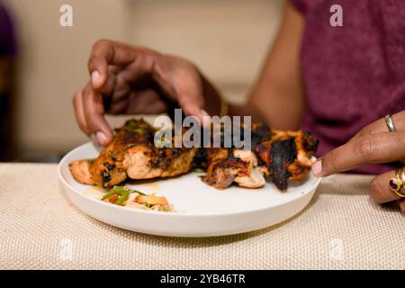 primo piano di delizioso pollo alla griglia speziato su un piatto, pronto per essere gustato. Foto Stock