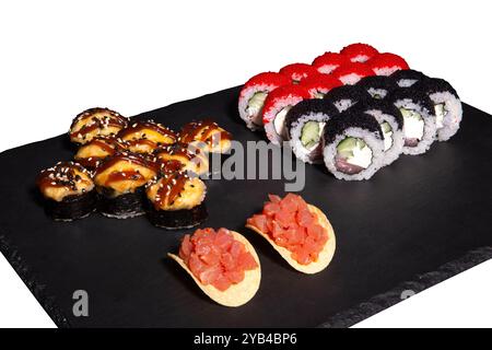 Sushi set e nachos con salmone su un piatto di ardesia isolato su sfondo nero. 3 tipi di rotoli in un unico set. Foto Stock