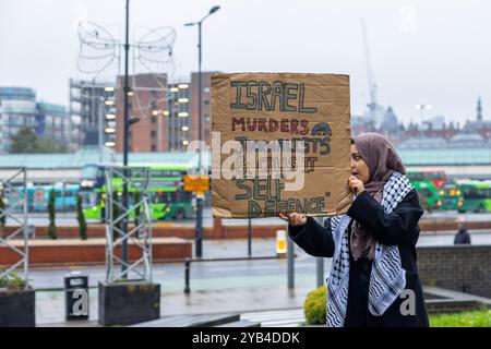 Leeds, Regno Unito. 16 OTTOBRE 2024. Lady tiene il cartello "Israele uccide giornalisti e lo chiama autodifesa” mentre i manifestanti palestinesi hanno organizzato una manifestazione fuori dagli uffici della BBC Yorkshire nel centro di Leeds accusandoli di parzialità nella copertura del conflitto di Gaza. C'era una presenza significativa della polizia e i manifestanti non sono entrati. A seguito di ciò i manifestanti si trasferirono alla stazione degli autobus di Leeds, dove un uomo era dirompente e presumibilmente assalì uno dei manifestanti, portando a parlare con entrambi gli uomini dalla polizia, non ci furono arresti. Credito Milo Chandler/Alamy Live News Foto Stock