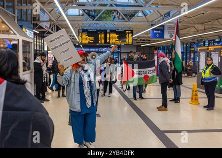 Leeds, Regno Unito. 16 OTTOBRE 2024. Il manifestante palestinese ha un segnale poco prima dell'incidente in cui un uomo è dirompente e presumibilmente assalto a favore del protestatore palestinese, portando a parlare con entrambi gli uomini dalla polizia. Non ci sono stati arresti. Questo avviene quando i manifestanti palestinesi hanno organizzato una dimostrazione all'interno della stazione degli autobus di Leeds in seguito alla protesta fuori dagli uffici della BBC Yorkshire nel centro di Leeds accusandoli di pregiudizi nella copertura del conflitto di Gaza. Credito Milo Chandler/Alamy Live News Foto Stock