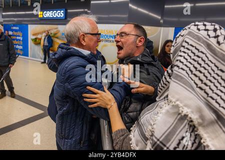 Leeds, Regno Unito. 16 OTTOBRE 2024. Un uomo è dirompente e presumibilmente assalto a favore del protestatore palestinese, portando a parlare con entrambi gli uomini dalla polizia, non ci sono stati arresti. Questo avviene quando i manifestanti palestinesi hanno organizzato una dimostrazione all'interno della stazione degli autobus di Leeds in seguito alla protesta fuori dagli uffici della BBC Yorkshire nel centro di Leeds accusandoli di pregiudizi nella copertura del conflitto di Gaza. Credito Milo Chandler/Alamy Live News Foto Stock