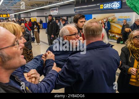 Leeds, Regno Unito. 16 OTTOBRE 2024. Un uomo è dirompente e presumibilmente assalto a favore del protestatore palestinese, portando a parlare con entrambi gli uomini dalla polizia, non ci sono stati arresti. Questo avviene quando i manifestanti palestinesi hanno organizzato una dimostrazione all'interno della stazione degli autobus di Leeds in seguito alla protesta fuori dagli uffici della BBC Yorkshire nel centro di Leeds accusandoli di pregiudizi nella copertura del conflitto di Gaza. Credito Milo Chandler/Alamy Live News Foto Stock