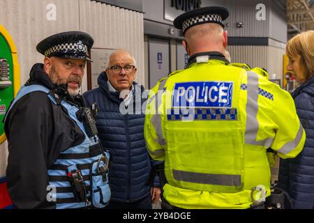 Leeds, Regno Unito. 16 OTTOBRE 2024. La polizia del West Yorkshire parla a un uomo dopo essere stato dirompente e aver presumibilmente aggredito un protestatore pro Palestina che ha portato a parlare con entrambi gli uomini dalla polizia, non ci sono stati arresti. Questo avviene quando i manifestanti palestinesi hanno organizzato una dimostrazione all'interno della stazione degli autobus di Leeds in seguito alla protesta fuori dagli uffici della BBC Yorkshire nel centro di Leeds accusandoli di pregiudizi nella copertura del conflitto di Gaza. Credito Milo Chandler/Alamy Live News Foto Stock