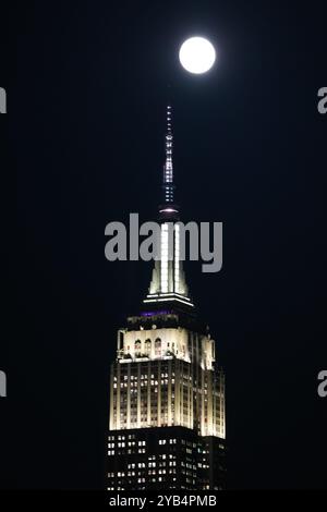 New York, New York, Stati Uniti. 16 ottobre 2024. Una luna piena sorge sull'Empire State Building il 16 ottobre 2024 a New York. La luna di Super Hunter di stasera, la luna piena più grande e luminosa dell'anno, è la luna piena più vicina dell'anno. (Immagine di credito: © Bryan Smith/ZUMA Press Wire) SOLO PER USO EDITORIALE! Non per USO commerciale! Foto Stock