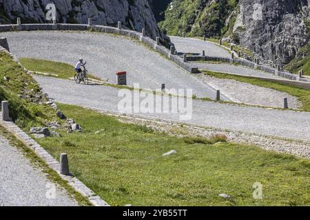 Ciclisti sulla strada di la Tremola, il passo alpino famoso in tutto il mondo che attraversa la Val Tremolo, il più lungo monumento di costruzione stradale della Svizzera con 24 hai Foto Stock