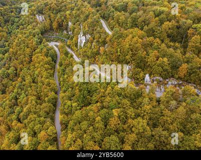 Albe sveva in autunno, Albtrauf con una foresta mista colorata e una strada di campagna tortuosa. Bad Urach, Baden-Wuerttemberg, Germania, Europa Foto Stock