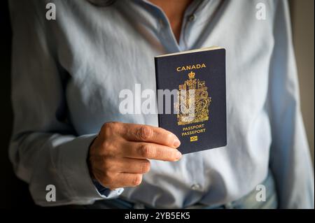 La donna ha in mano un passaporto canadese, pronta a intraprendere un viaggio internazionale Foto Stock