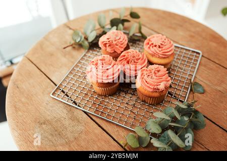 Catering, cupcake e presentazione su tavolo di legno per ospitalità, startup o servizio di piccole imprese. Sfondo, dessert e cibo in esposizione Foto Stock