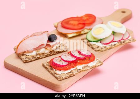 Diversi tipi di pane integrale con Prato, pomodoro, Rasth, cetriolo e formaggio. Colazione facile. Dieta alimentare. Panini veloci e sani. Croccante con gustoso ripieno. Snack dietetico sano Foto Stock