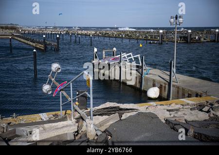 Umido, Germania. 16 ottobre 2024. Un lampione caduto e un cartello giacciono sulla banchina strappata del porto in umido. Un'ondata di tempesta baltica ha danneggiato o distrutto dighe e strutture portuali lungo la costa nell'autunno del 2023. Crediti: Hannes P. Albert/dpa/Alamy Live News Foto Stock