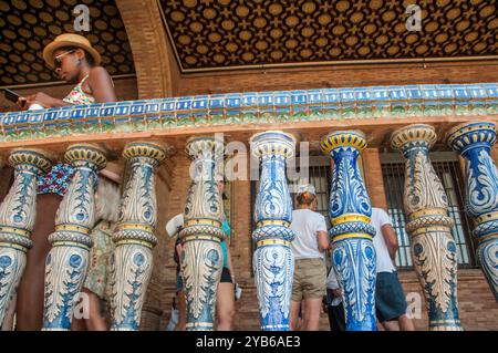 Un turista nero dietro la balaustra in ceramica in Plaza de España, Siviglia, Spagna. Foto Stock