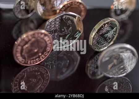 Sterling Coins, sua altezza reale Re Carlo III, in piedi su un top nero riflettente Foto Stock