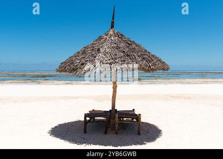 Ombrellone solitario sulla spiaggia durante la bassa marea Foto Stock