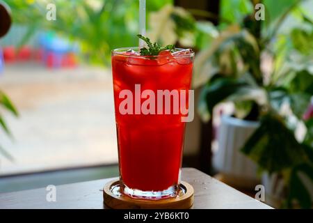 Un cocktail trasparente monocolore, rinfrescante in un bicchiere basso con cubetti di ghiaccio e assaggio di frutti di bosco, ciliegie, fragole, greiprut. Vista laterale. Sfondo bianco isolato. Drink per il menu Foto Stock