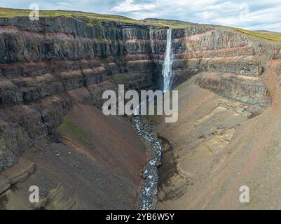 Cascata Hengifoss, strati basaltici intrecciati con strati sedimentari rossi, vista aerea, Islanda Foto Stock