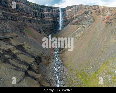 Cascata Hengifoss, strati basaltici intrecciati con strati sedimentari rossi, vista aerea, Islanda Foto Stock