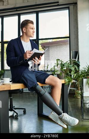 Un giovane uomo d'affari con una gamba protesica scrive con cura su un quaderno durante l'orario di lavoro. Foto Stock