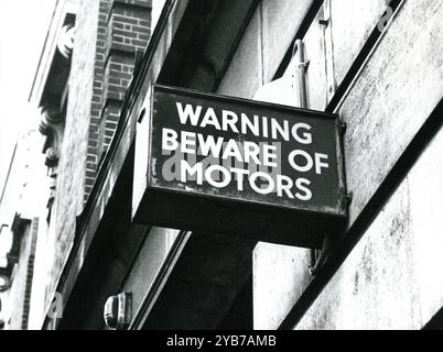 Un cartello sul lato di un edificio che dice attenzione alla motori a Camden Town a Londra, Inghilterra, il 1° luglio 1978. Foto Stock