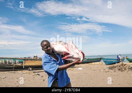 Un pescatore con il suo pescato a Kasensero, cittadina di pescatori sulle rive del lago Victoria - Uganda Foto Stock