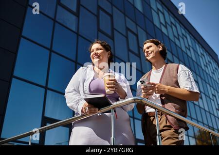 Una giovane donna felice e la sua amica si godono il sole e chiacchierano sul balcone. Foto Stock