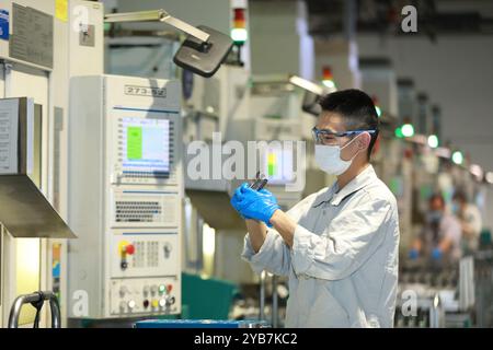 Wuxi. 17 ottobre 2024. Questa foto del file scattata il 25 febbraio 2020 mostra un tecnico che lavora presso Bosch Powertrain Systems Co., Ltd. A Wuxi, nella provincia di Jiangsu nella Cina orientale. Il gigante multinazionale tedesco Bosch Group ha firmato un accordo mercoledì sera per la creazione della sua sede centrale strategica in Cina per i veicoli commerciali nella città di Wuxi, nella provincia di Jiangsu, nella Cina orientale, indicando la sua timidezza nei confronti dei nuovi veicoli energetici e delle industrie di guida intelligente cinesi. PER ANDARE CON "Economic Watch: La Germania Bosch lancerà un progetto strategico di veicoli commerciali in Cina" credito: Xinhua/Alamy Live News Foto Stock