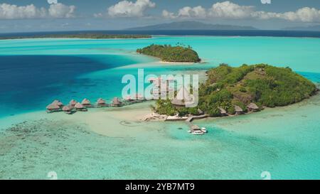 Vista aerea del resort di lusso nella tropica Bora Bora, Polinesia francese, bungalow sull'acqua sistemazione remota in hotel sulla barriera corallina laguna turchese. Paradiso naturale selvaggio, esotico sfondo di viaggi estivi Foto Stock